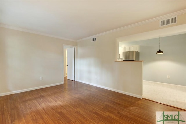 unfurnished room with ornamental molding and hardwood / wood-style floors