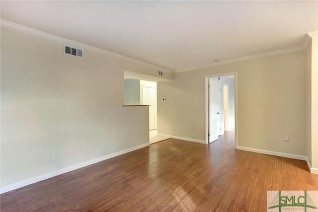 spare room featuring hardwood / wood-style flooring and crown molding