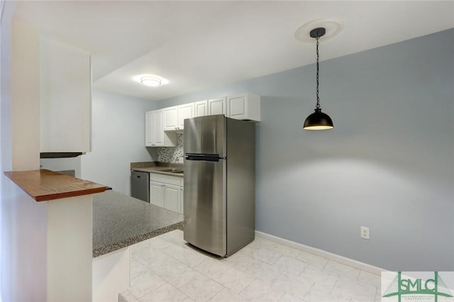 kitchen featuring white cabinetry, decorative light fixtures, kitchen peninsula, stainless steel appliances, and decorative backsplash