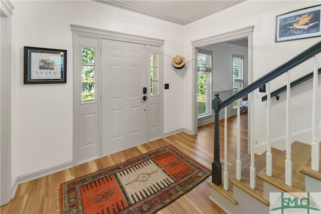 foyer entrance featuring crown molding and light wood-type flooring