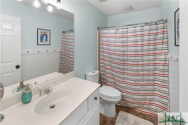 bathroom featuring tile patterned flooring, vanity, a shower with shower curtain, and toilet