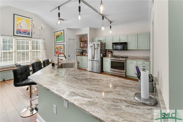 kitchen with a breakfast bar, pendant lighting, sink, light stone counters, and stainless steel appliances