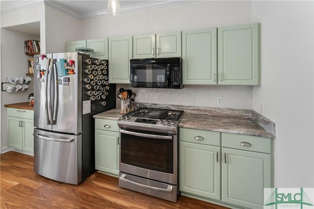 kitchen featuring ornamental molding, stainless steel appliances, green cabinetry, and light wood-type flooring