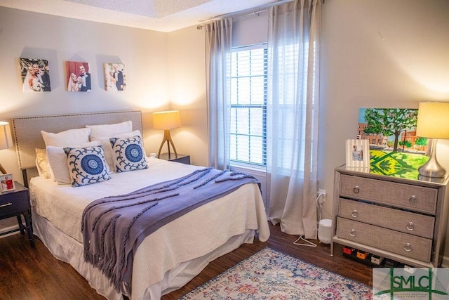 bedroom with dark wood-type flooring