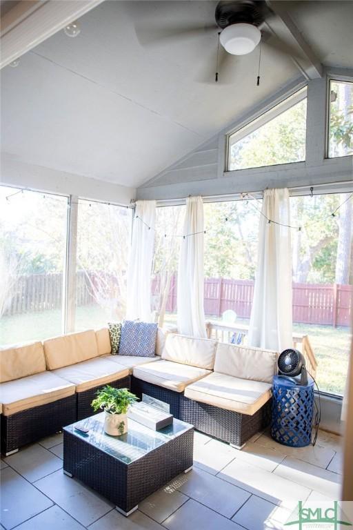 sunroom / solarium featuring lofted ceiling with beams, a wealth of natural light, and ceiling fan