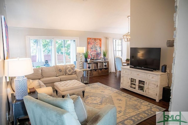 living room with vaulted ceiling, dark wood-type flooring, and a notable chandelier