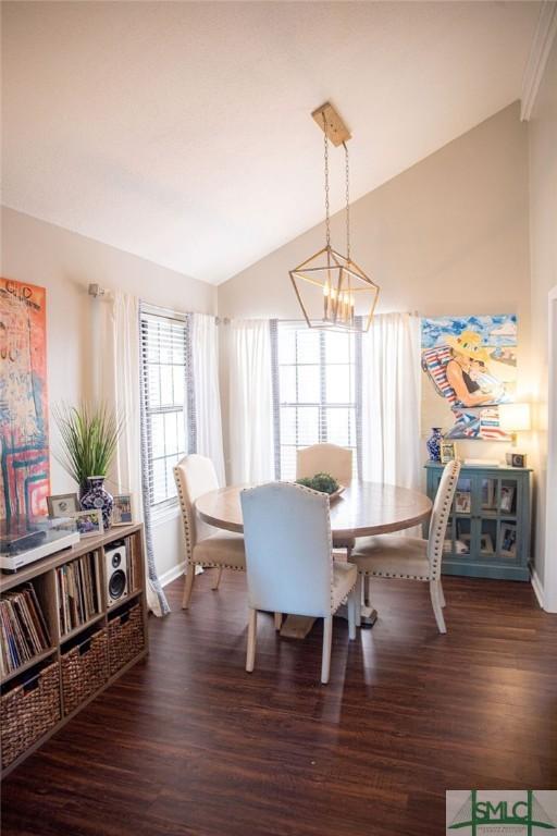 dining area featuring dark hardwood / wood-style floors, vaulted ceiling, and a notable chandelier