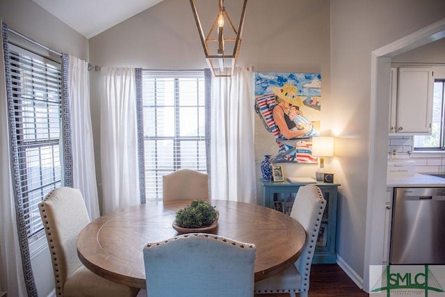 dining space featuring vaulted ceiling, a notable chandelier, and dark hardwood / wood-style flooring