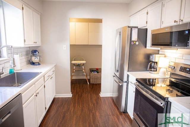 kitchen featuring white cabinetry, decorative backsplash, dark wood-type flooring, and appliances with stainless steel finishes