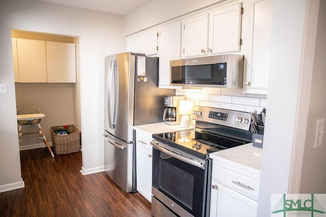 kitchen featuring white cabinetry, appliances with stainless steel finishes, dark wood-type flooring, and decorative backsplash