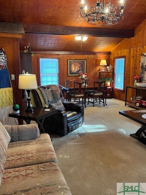 living room featuring wood walls, wood ceiling, lofted ceiling with beams, a notable chandelier, and light colored carpet