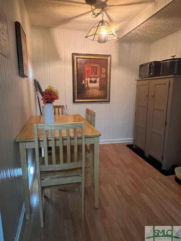 dining room featuring hardwood / wood-style floors and a textured ceiling