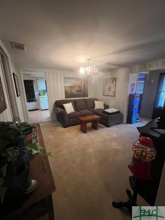 living room featuring a chandelier and carpet flooring