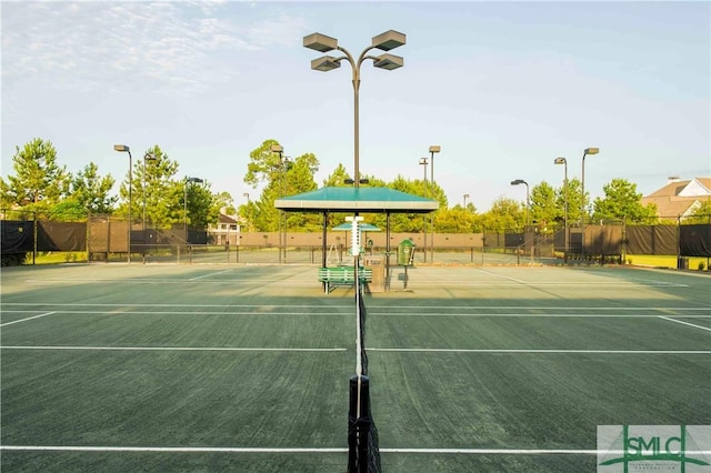 view of tennis court with a playground