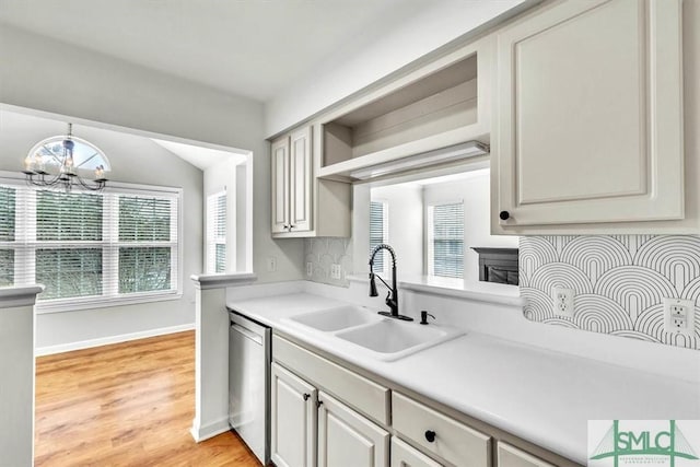 kitchen featuring a healthy amount of sunlight, sink, stainless steel dishwasher, and a chandelier