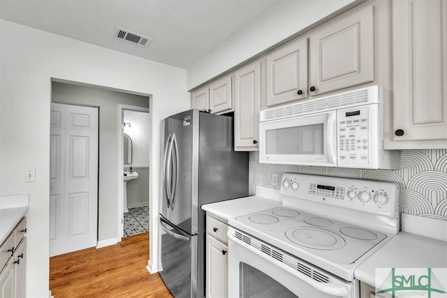 kitchen with white appliances and light hardwood / wood-style flooring