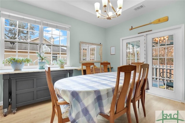 dining space with a chandelier and light wood-type flooring