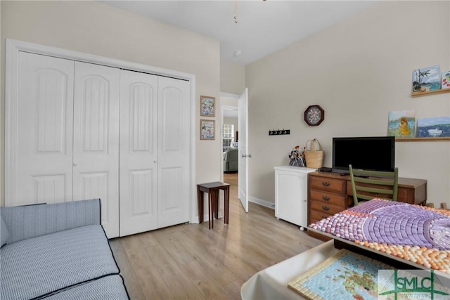 bedroom with light hardwood / wood-style floors and a closet