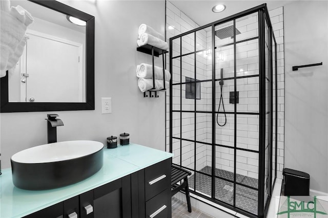 bathroom featuring a tile shower and vanity