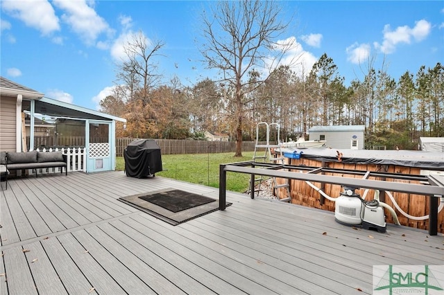 deck with a grill, a yard, a sunroom, and a storage unit