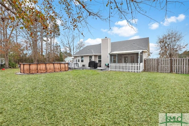 rear view of house with a patio, a sunroom, and a yard