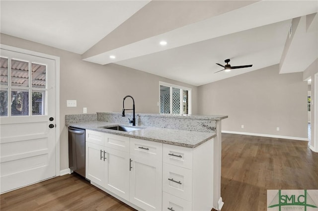 kitchen featuring sink, white cabinetry, light stone counters, vaulted ceiling, and kitchen peninsula