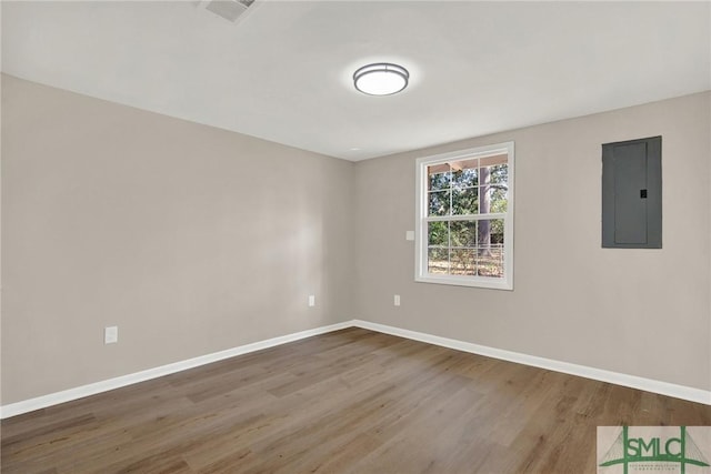 spare room with hardwood / wood-style flooring and electric panel