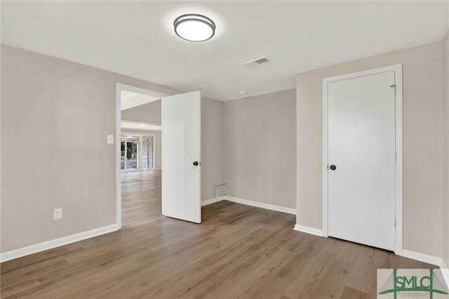 empty room with light hardwood / wood-style flooring