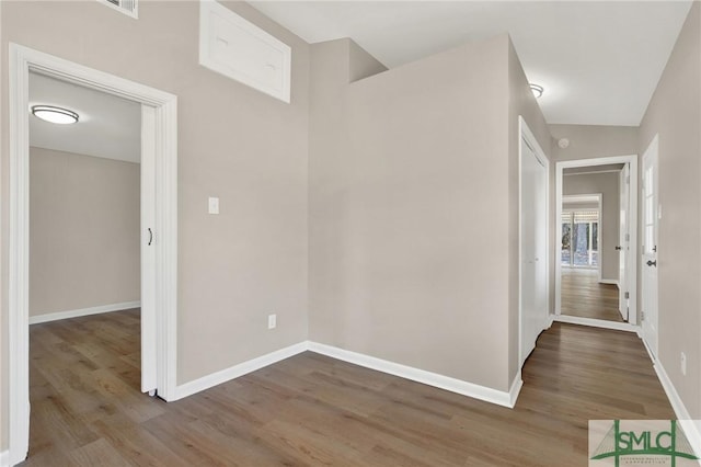 hallway with hardwood / wood-style floors