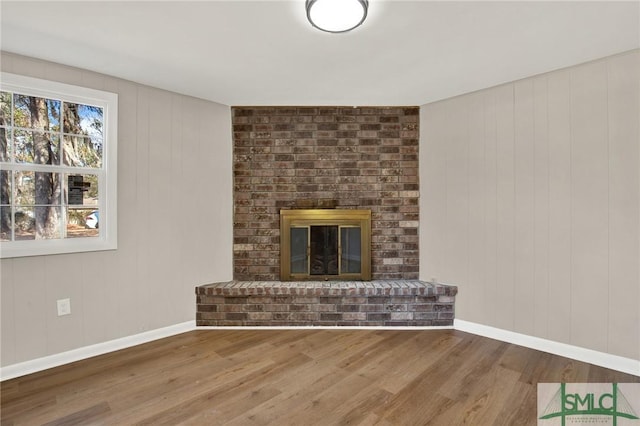 unfurnished living room featuring wood-type flooring and a fireplace