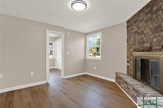 unfurnished living room featuring wood-type flooring and a fireplace