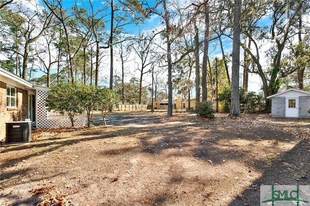 view of yard featuring central AC and a storage unit