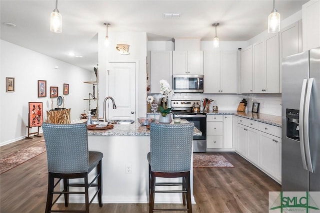 kitchen with white cabinetry, sink, pendant lighting, and appliances with stainless steel finishes