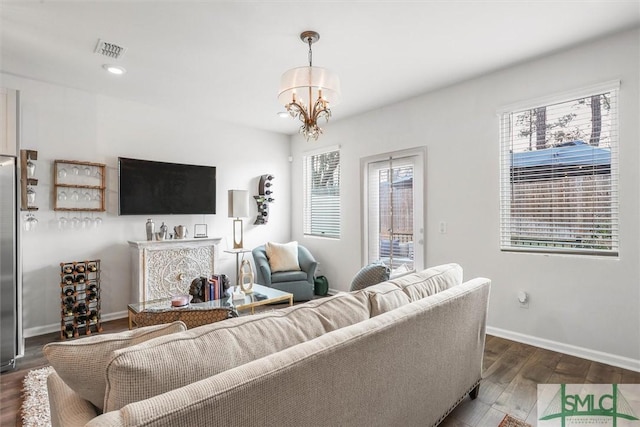 living room with dark hardwood / wood-style floors and a chandelier