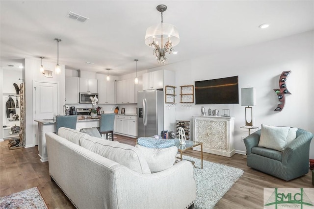 living room with a notable chandelier and light hardwood / wood-style flooring