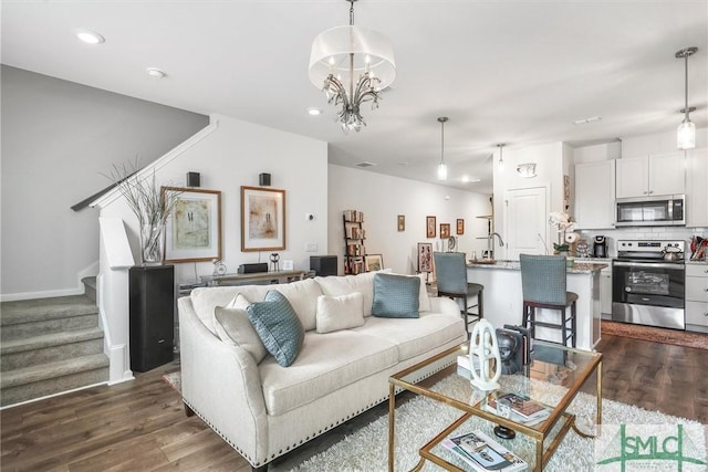 living room with dark wood-type flooring and a chandelier