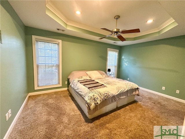 bedroom featuring carpet, a raised ceiling, visible vents, and crown molding