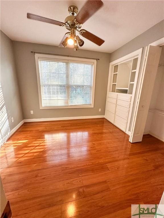 unfurnished bedroom with light wood finished floors, a ceiling fan, and baseboards