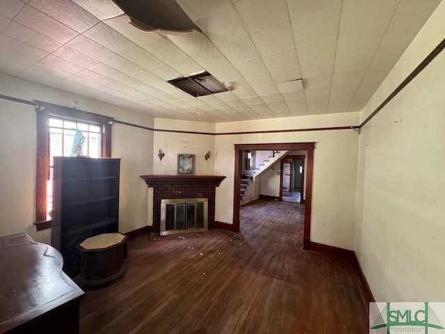 unfurnished living room featuring a fireplace and dark wood-type flooring