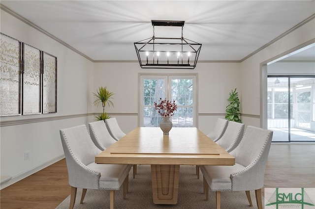 dining area with hardwood / wood-style flooring and ornamental molding