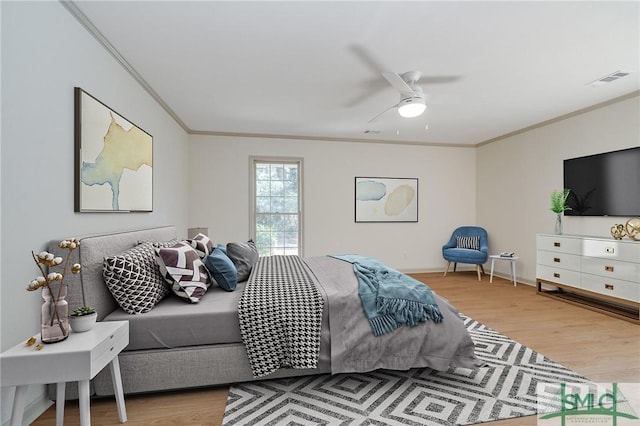 bedroom featuring ceiling fan, ornamental molding, and hardwood / wood-style floors