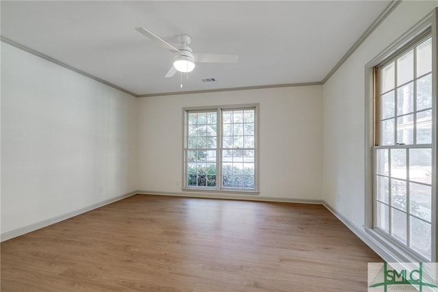 empty room featuring crown molding, plenty of natural light, and light wood-type flooring