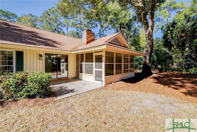 rear view of house featuring a patio and a sunroom