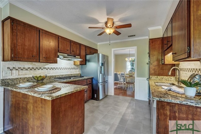 kitchen with stainless steel appliances, crown molding, ceiling fan, and light stone counters