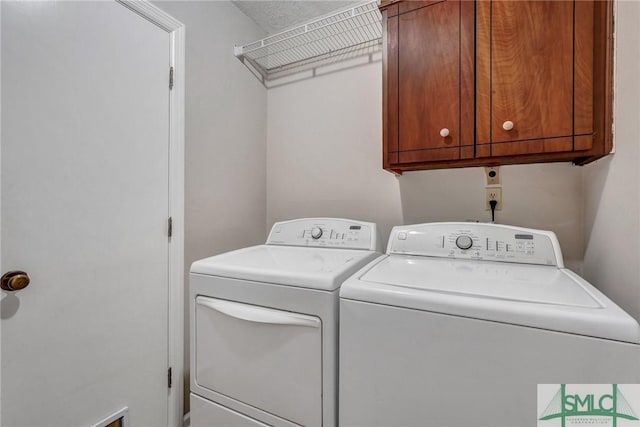 washroom with separate washer and dryer and cabinets