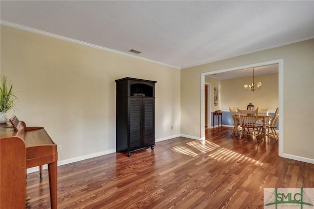 living room with ornamental molding, hardwood / wood-style floors, and a notable chandelier