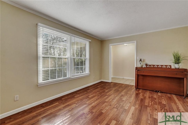 unfurnished room with ornamental molding, wood-type flooring, and a textured ceiling