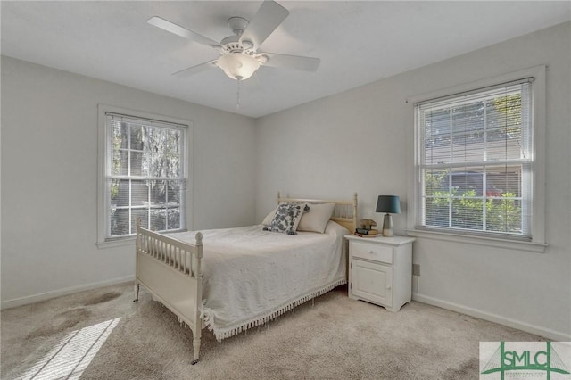 carpeted bedroom featuring multiple windows and ceiling fan