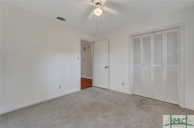 unfurnished bedroom with ceiling fan, a closet, and light carpet