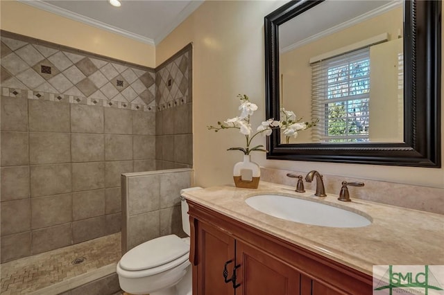 bathroom with tiled shower, ornamental molding, toilet, and vanity